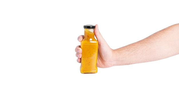 Salsa in bottiglia isolata su uno sfondo bianco. bottiglia in mano. foto di alta qualità