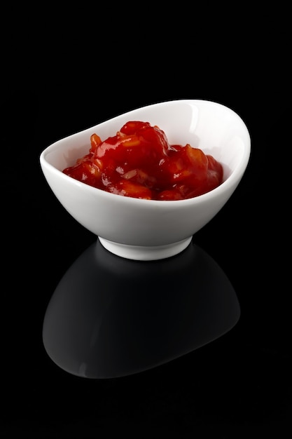 Sauce in a white bowl on black