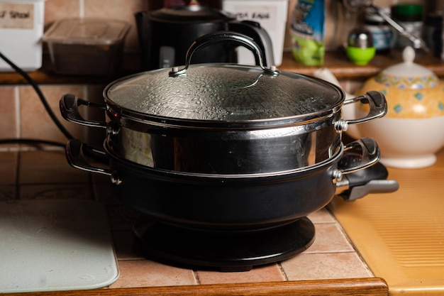 Pentola a vapore elettrica sul tavolo della cucina un dispositivo moderno  in metallo per la cottura a vapore di alimenti dietetici