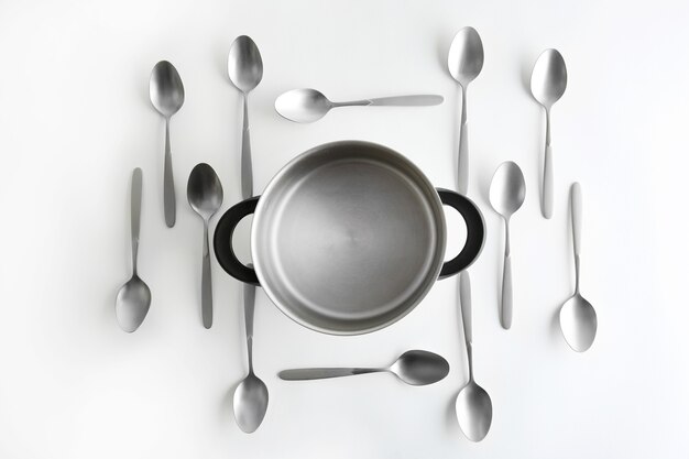 Saucepan and silver spoons, top view