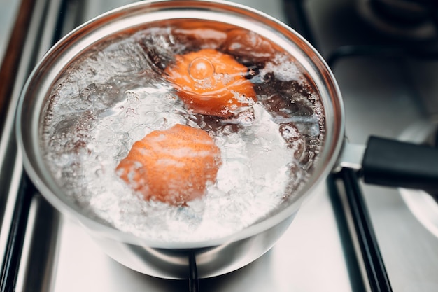 写真 ガスストーブの水で卵を沸かすステンレス鋼の鍋の朝食