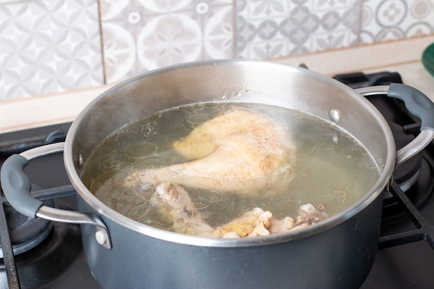 Saucepan with bouillon on the stove. Bone broth. Chicken bouillon