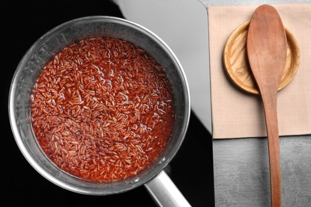 Premium Photo | Saucepan with brown rice on stove