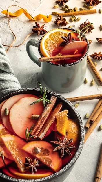 A saucepan with mulled wine and a mug are on a light background. Top view.