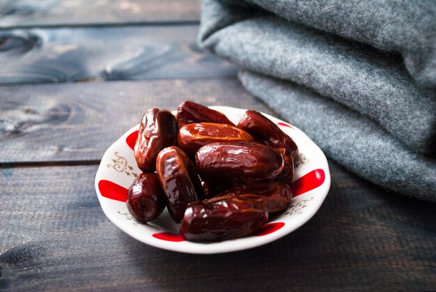 Saucer of date fruits and folded grey blanket