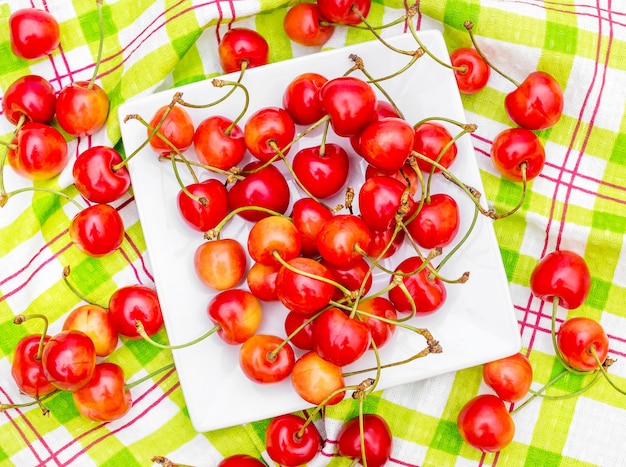 Saucer with cherries on the kitchen towel Top view