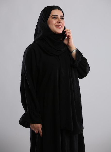 Photo saudi arabian woman wearing abaya standing calling on phone