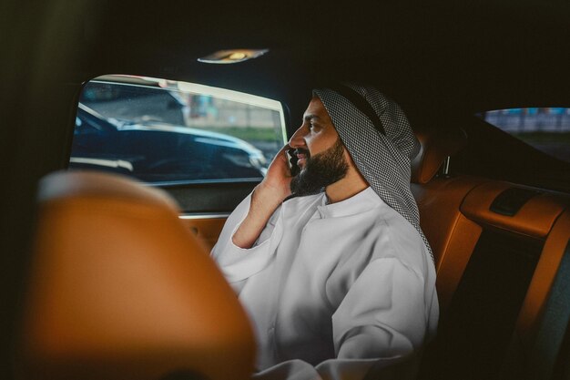 車に座って電話で話しているサウジアラビア人