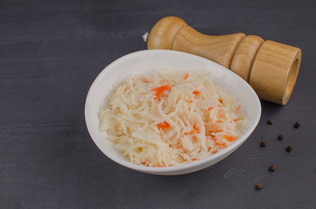 Sauerkraut and carrots in a plate. horizontal view from above, rustic style. Fermented food. Copy space.