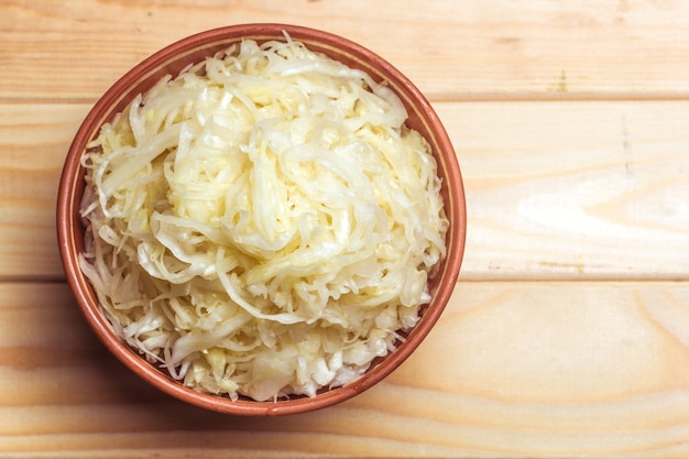 Sauerkraut in a clay plate on a wooden table