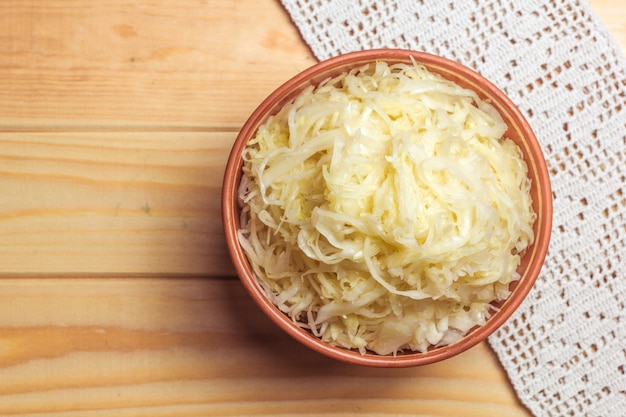 Sauerkraut in a clay plate on a wooden table