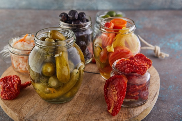 Crauti, carote sott'aceto, cetrioli sott'aceto, olive e olive in salamoia, pomodori secchi in vasetti di vetro