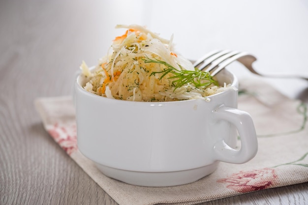 sauerkraut with carrots and spices in a white bowl