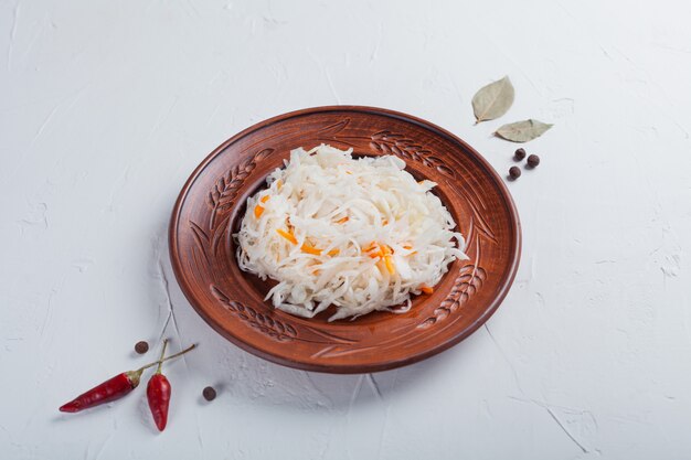 Sauerkraut with ingredients on a white table