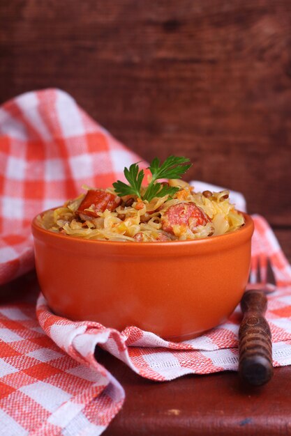 Sauerkraut with sausage and lentils in a clay bowl