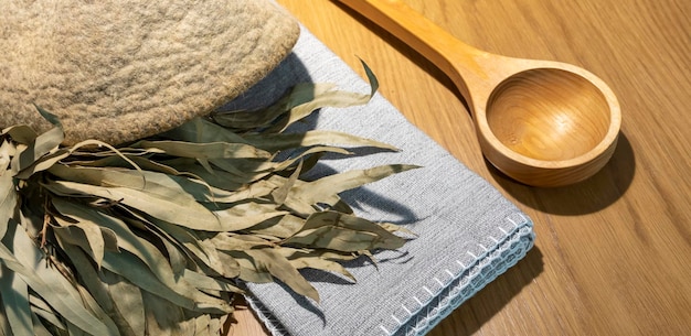 Sauna accessories in the steam room. brush, soap, broom, hat, linen towel. flat lay. copy space