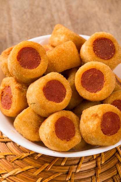 Sausage fried snacks. Brazilian snacks on wooden background.