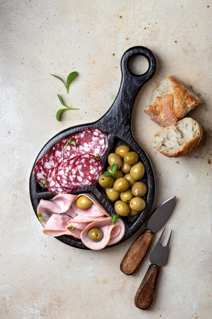 Sausage and green olive on a round cutting board