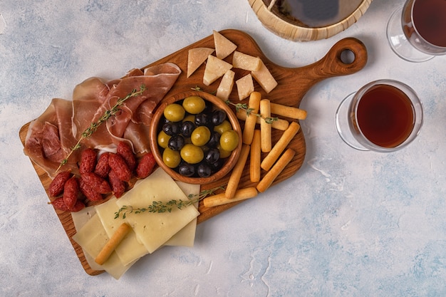 Sausage, olives, prosciutto, breadsticks, and wine