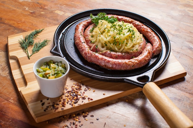 Колбаса и лук на деревянном столе