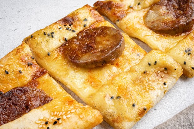 Pide di salsiccia o pizza di salsiccia sucuklu pide su sfondo grigio tavola primo piano macro