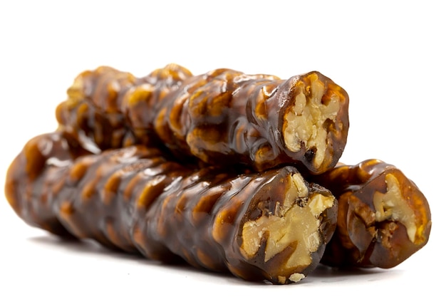 Sausage walnuts on a white background Turkish walnut raisin sausage sweet A sweet snack made by drying molasses and walnuts local name ceviz sucuk