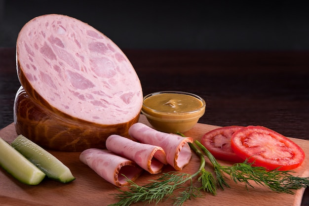 Sausage with appetizers in a plate and on a cutting board.