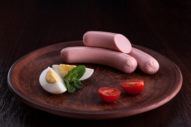 Sausage with appetizers in a plate and on a cutting board.