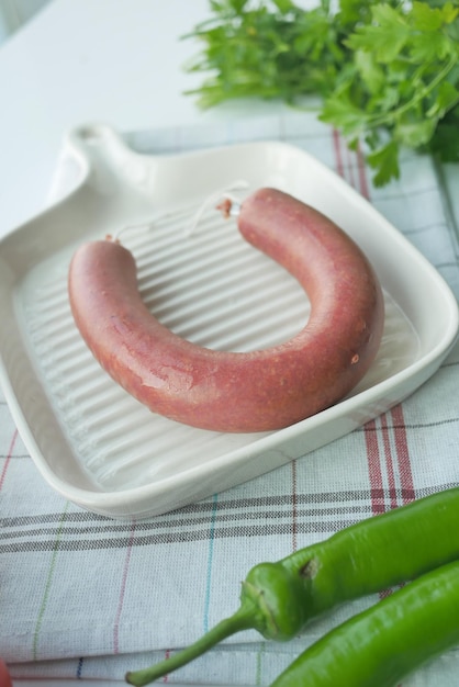 Sausages and chili with table cloth on table