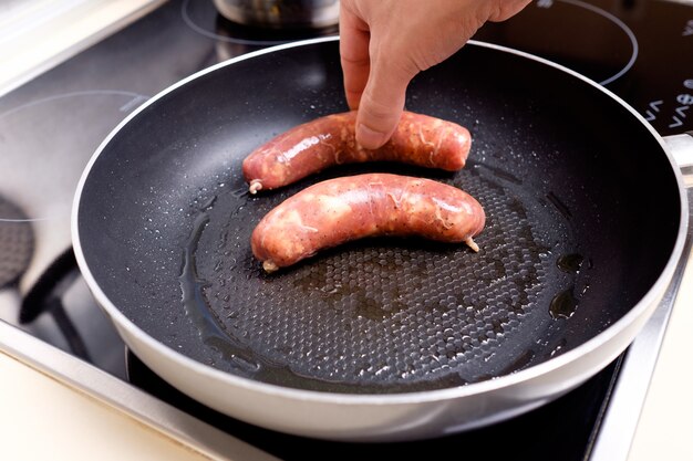 Foto salsicce cucinare sulla padella