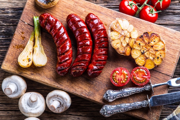 Salsicce. salsicce alla griglia. salsiccia alla griglia con funghi aglio pomodori e cipolle.