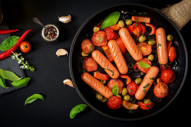 Sausages grilled with vegetables in the Greek style on pan. Flat lay. Top view.
