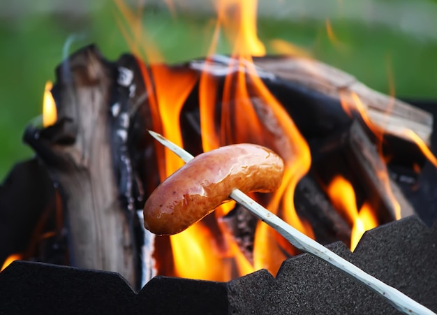 Sausages grilling for a picnic outdoors over the brazier