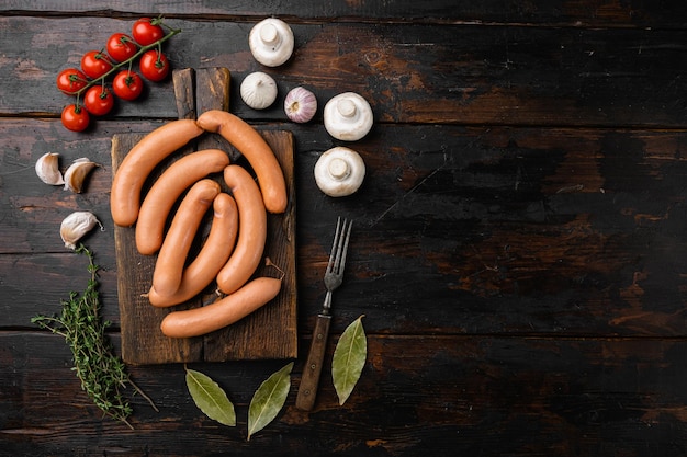 Photo sausages on old dark wooden table background top view flat lay with copy space for text