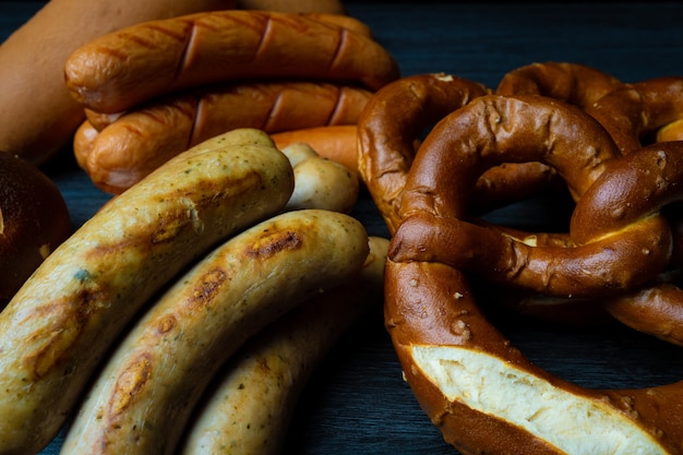 sausages and pretzels background on wood table oktoberfest dark food style