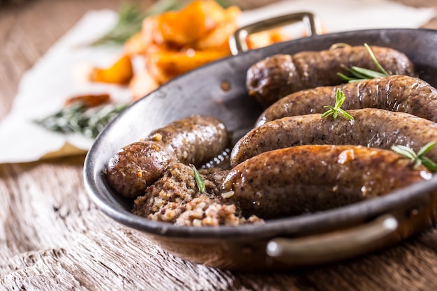 Sausages.Roasted varkensworst in een pan met aardappelen en rozemarijn.