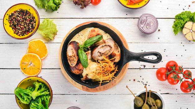 Sausages in sauce and vegetables in a frying pan On a wooden table Top view Copy space