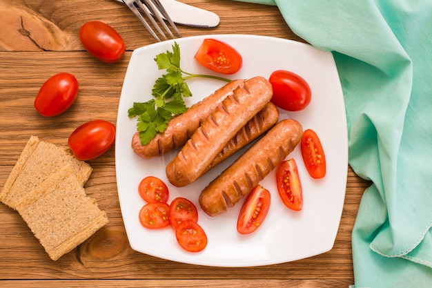 Sausages, tomatoes and bread. View from above