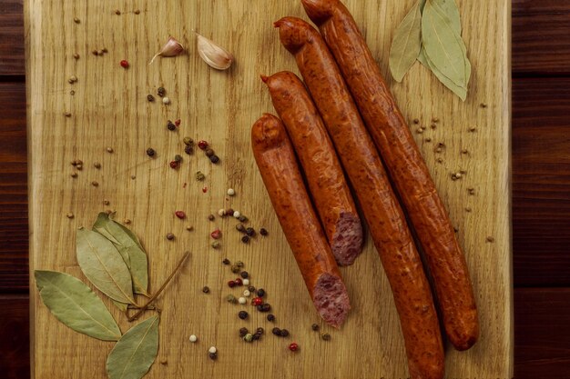 Sausages on a wooden board with garlic and spices