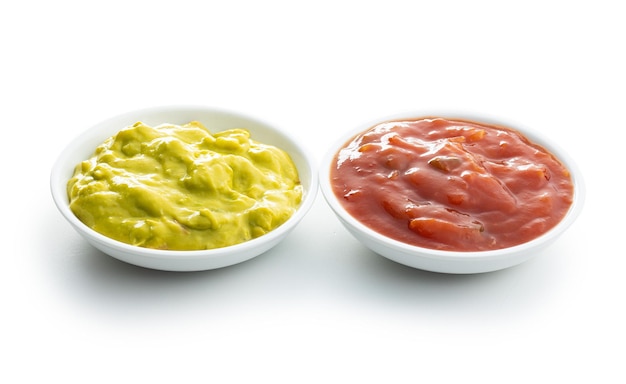 Sauzen in kom Guacamole en tomatenonderdompeling die op witte achtergrond wordt geïsoleerd