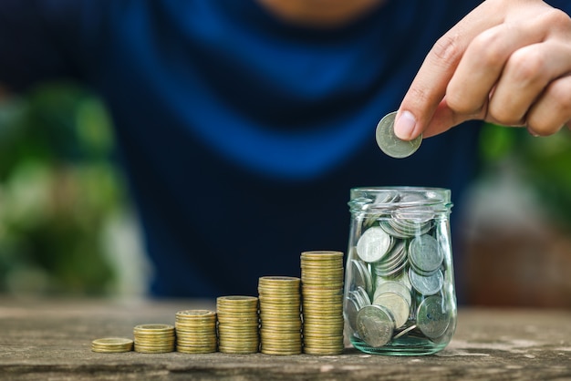 Photo save money concept with hand holding coin on coins stack growing business