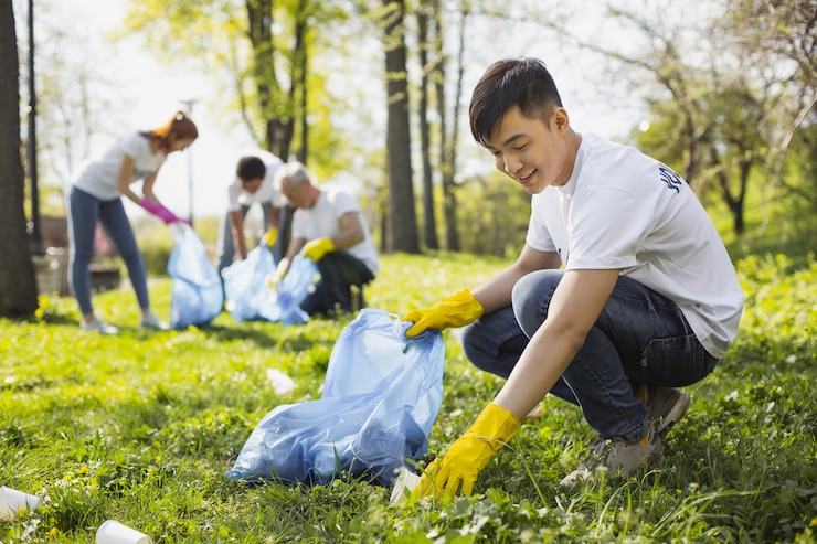 Photo save nature. happy male volunteer using garbage bag while gathering litter