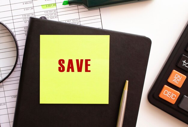 SAVE text on a sticker on your desktop. Diary, calculator and pen. Financial concept.