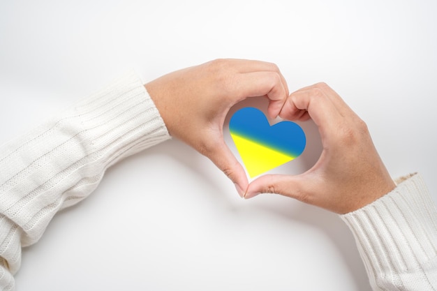 Save ukraine no more war in the concept of woman hand and the\
flag in heart shape the patriotism and protect the people of\
ukraine