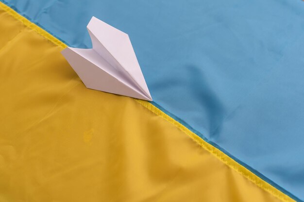 Save ukraine. paper airplane on the background of the flag of
ukraine, help and charity. art collage.