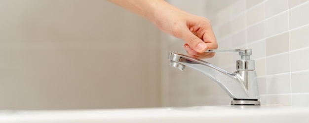 Save water Volunteer keeps turning off the running water in the bathroom to protect environment Greening planet reduce global warming Save world life future risk energy crisis water day