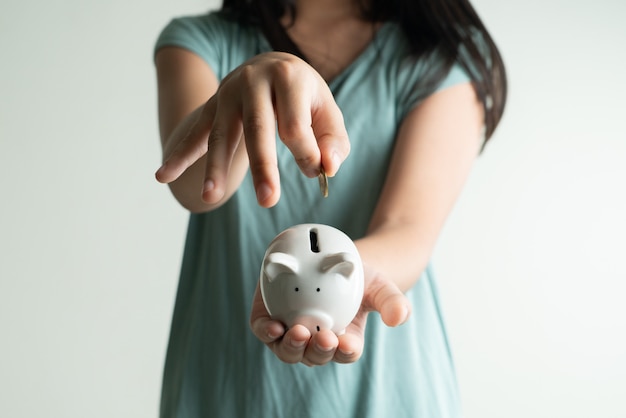 Saving and business concept, Cute girl with piggy bank and coins at home