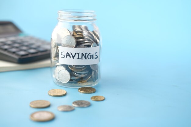 Saving coins jar and calculator on table