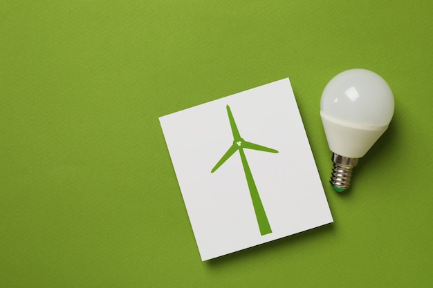 Saving electricity concept on green background, space for text.