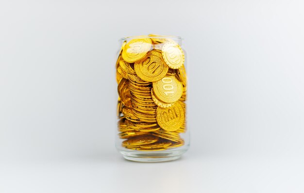 ゴールドコインをガラスの容器に貯める 貯蓄の概念 財務計画と投資